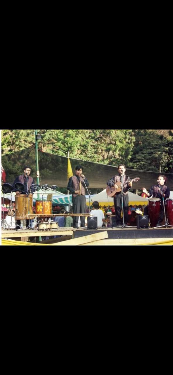 Grupo de estudiantes y músicos en un escenario.